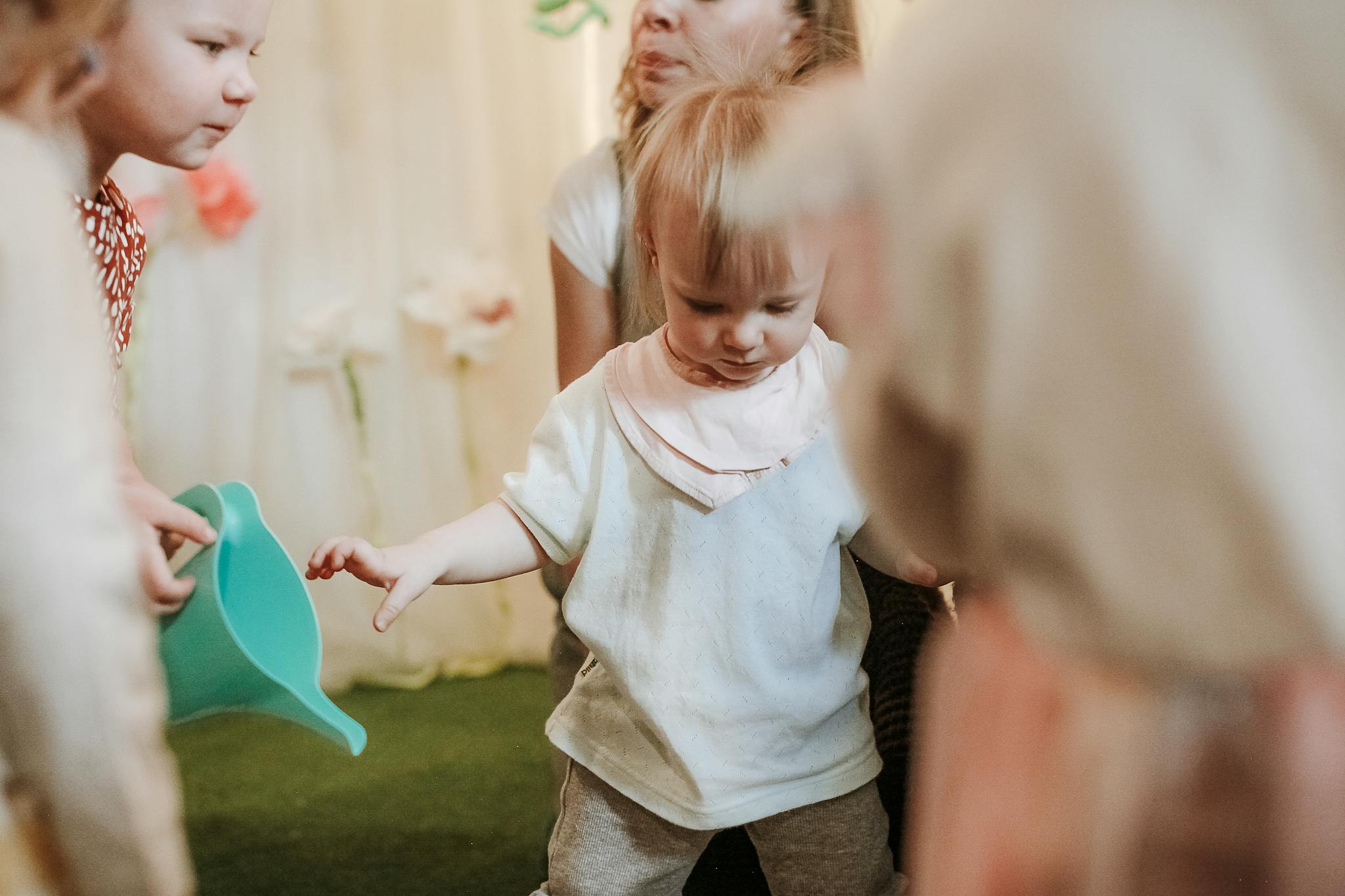 Young children playing and exploring in an indoor preschool environment.
